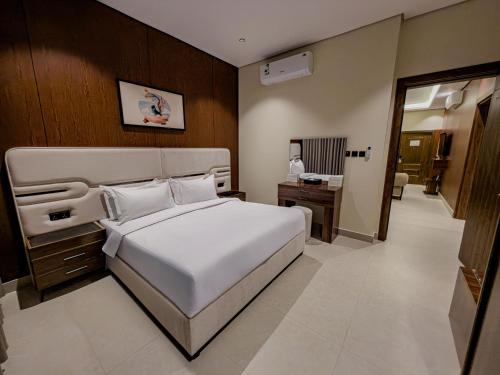 a bedroom with a large white bed and a desk at Tura Residence Al Khaleej- ترى للشقق المخدومة الخليج in Riyadh