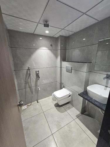 a bathroom with a shower and a toilet and a sink at Hotel Shivalik inn in Ankleshwar