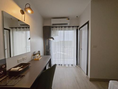 a bathroom with a vanity and a mirror and a window at Remas Hotel Hat Yai in Ban Tha Thon