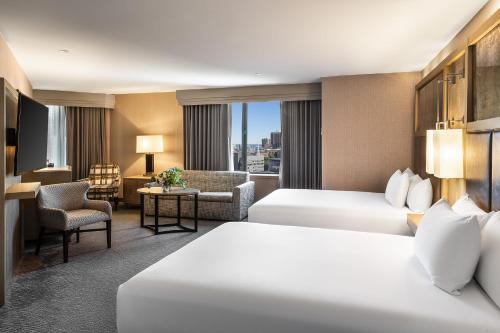a hotel room with two beds and a living room at Hyatt Regency Boston in Boston