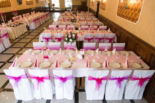 a banquet hall with tables and chairs with pink bows at Hotel Róża in Kamieniec Wrocławski