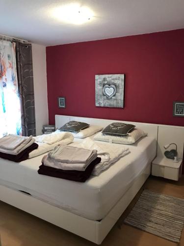a bedroom with two beds and a red wall at Golfhues-Simone-EG-Appartement-mit-grossem-Garten in Wulfen auf Fehmarn