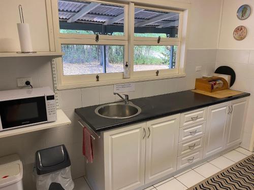 a kitchen with a sink and a microwave at Winganna Farm in Peel