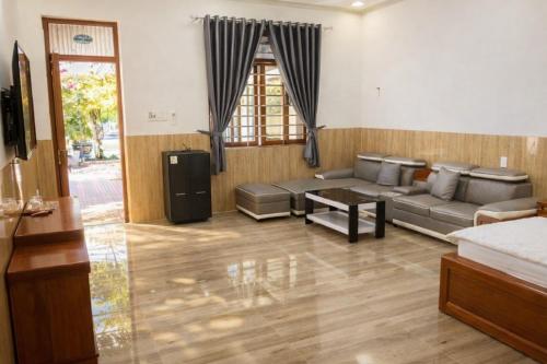 a living room with a couch and a table at Sơn Hiển Homestay in Cam Lâm