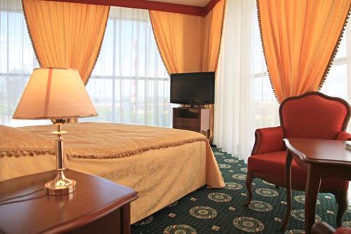 チェレポヴェツにあるArm Premier Hotelのベッドと椅子付きのホテルルーム