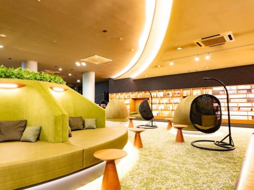 a living room with a couch and chairs and tables at Hotel Flags Sasebo KujuKusima in Sasebo