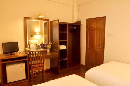 a bedroom with a desk with a computer and a bed at Sourire at Rattanakosin Island Hotel in Bangkok