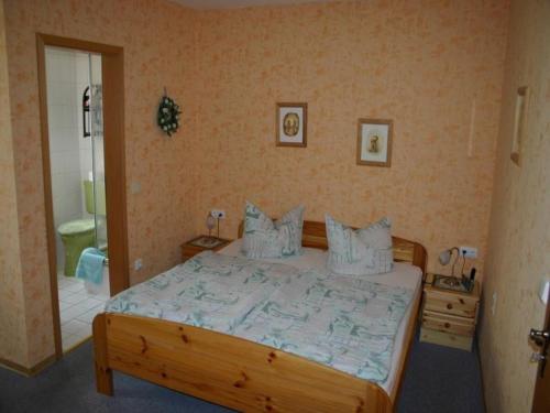 a bedroom with a large wooden bed with pillows at Haus-Kummeleck-Wohnung-4 in Bad Lauterberg