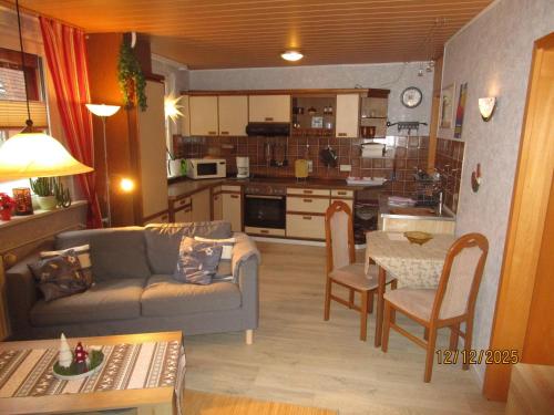 a living room and kitchen with a couch and a table at Haus-Kummeleck-Wohnung-4 in Bad Lauterberg