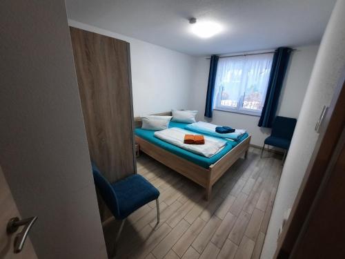 a bedroom with a bed and a chair and a window at Haus-Hempel-1 in Groß Mohrdorf