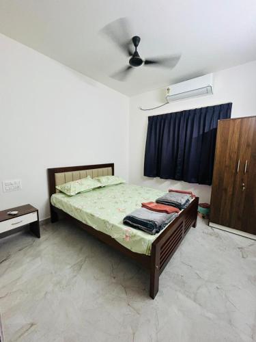 a bedroom with a bed and a ceiling fan at Mangalore serviced flats in Mangalore