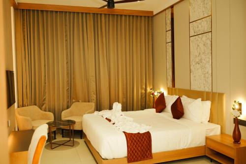 a hotel room with a bed and a table and chairs at Dwaraka INN in Arīkkod