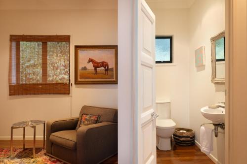 a bathroom with a chair and a horse painting on the wall at Balmoral 575 in Montville