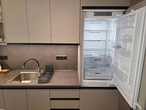 an empty refrigerator with its door open in a kitchen at Velithea Luxury Suites in Ioannina