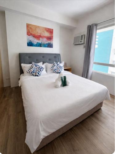 a bedroom with a large white bed with blue pillows at Sebby Studio in Bacolod