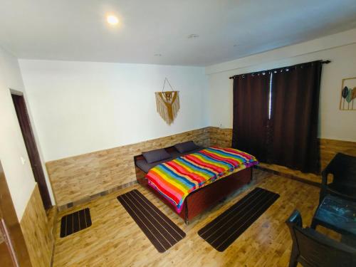 a bedroom with a couch with a colorful blanket on it at Parbati Headquarters in Kasol