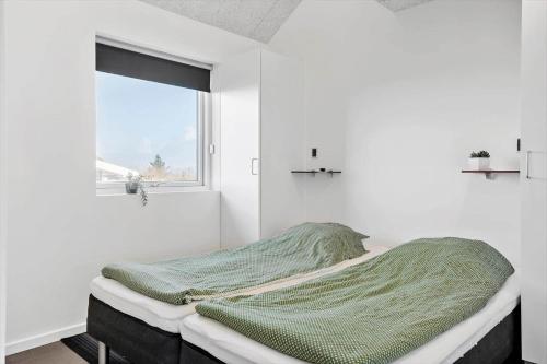 a bed in a white room with a window at G331-Lemvig-Myntevej-31 in Lemvig