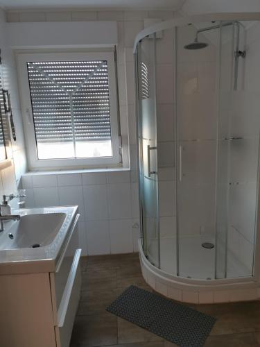 a bathroom with a shower and a sink and a window at Gästehaus Sol Tour in Ahrensfelde