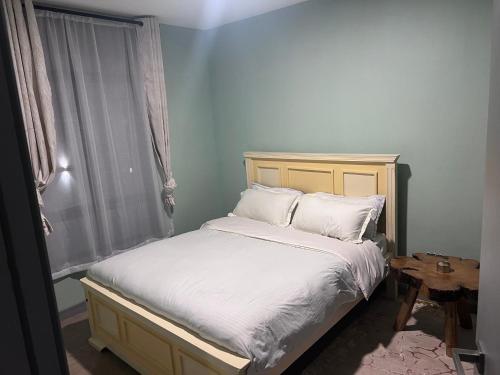ein Bett mit weißen Laken und Kissen neben einem Fenster in der Unterkunft Maisha Mapya in Gatimu