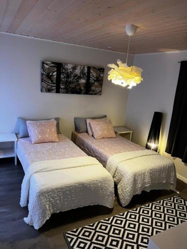 a bedroom with two beds and a chandelier at Aurora Gateway N4 in Inari