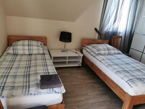 a bedroom with two beds and a table with a lamp at Gästehaus Sol Tour in Ahrensfelde