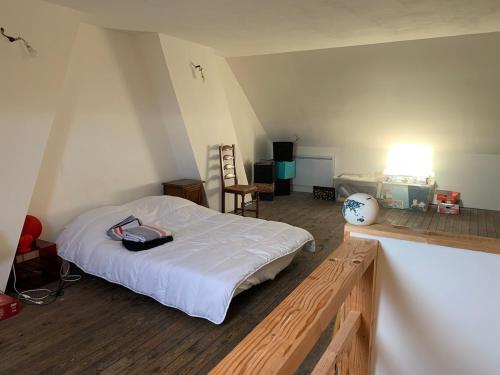 a bedroom with a bed with white sheets and a table at Maison cocooning in Hazebrouck