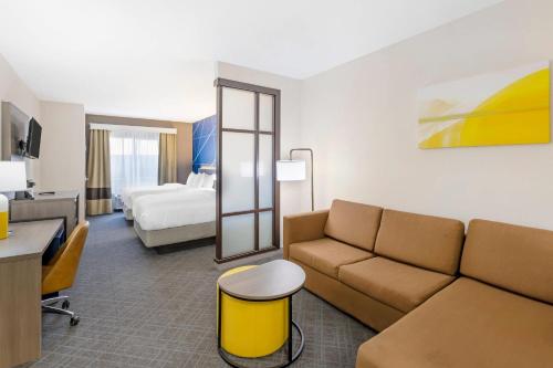 a hotel room with a couch and a bed at Comfort Suites Pecos in Pecos