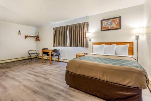 a hotel room with a bed and a desk at Econo Lodge Saint Albans in Saint Albans