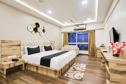 a hotel room with a bed and a television at Townhouse Oak PTC Indore Junction in Indore