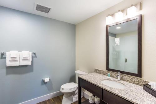 a bathroom with a sink and a toilet and a mirror at MainStay Suites Logan Ohio-Hocking Hills in Logan