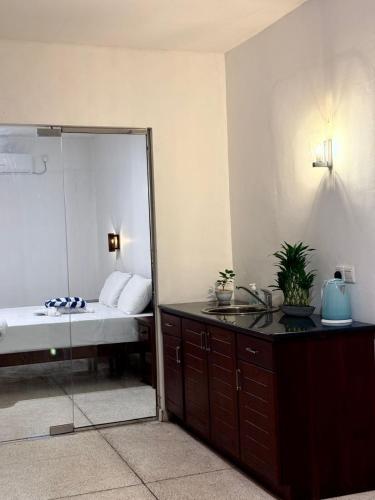 a bathroom with a mirror and a bed and a sink at The Kasbo in Unawatuna