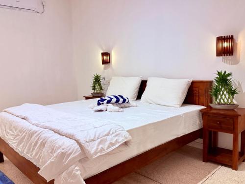 a bedroom with a large bed with white sheets at The Kasbo in Unawatuna