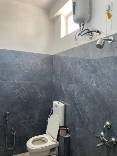 a bathroom with a toilet and a window at Hotel shree shiv in Indore