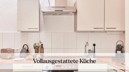 a white kitchen with white cabinets and appliances at Traumferienwohnung Domblick - Parkplatz inklusive, zentral mit Altstadtblick & Netflix in Limburg an der Lahn