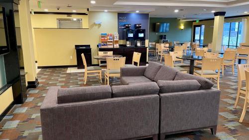 a living room with a couch and tables and chairs at Holiday Inn Express and Suites Detroit North-Troy by IHG in Troy