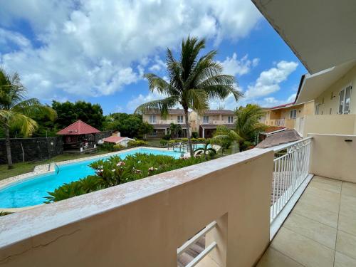 a view from the balcony of a resort with a swimming pool at Cozy 3BR Duplex with Pool & Garden View - Grand Gaube Getaway in Grande Gaube