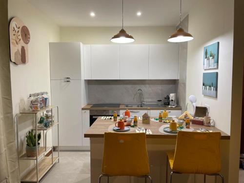 a kitchen with white cabinets and yellow chairs at Il Piccolo Scrigno 2 in Lonigo