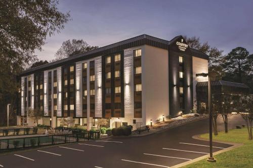 a hotel with a parking lot in front of it at Country Inn & Suites by Radisson, Williamsburg East Busch Gardens , VA in Williamsburg