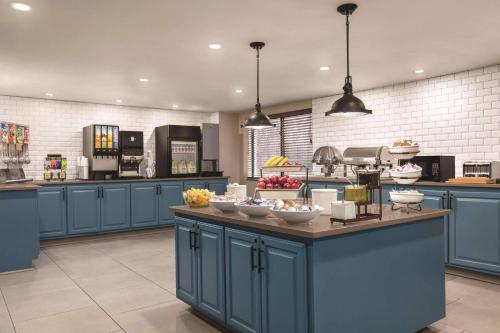 a kitchen with blue cabinets and bowls of food on a counter at Country Inn & Suites by Radisson, Williamsburg East Busch Gardens , VA in Williamsburg