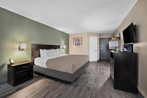 a hotel room with a bed and a flat screen tv at Quality Inn Fort Myers Cape Coral in Fort Myers