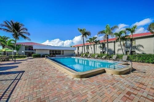 a swimming pool with chairs and a building at Quality Inn Fort Myers Cape Coral in Fort Myers