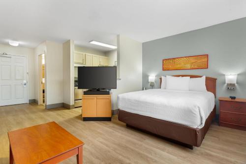 a bedroom with a bed and a flat screen tv at MainStay Suites Tampa Moffitt-USF in Tampa