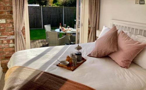 a white bed with a tray of food on it at The Stables in Metheringham