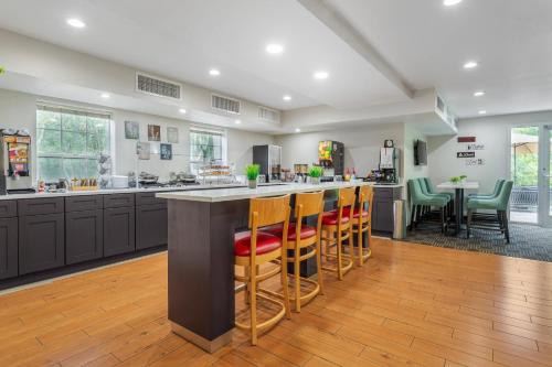 a kitchen with a large island with bar stools at MainStay Suites Tampa Moffitt-USF in Tampa