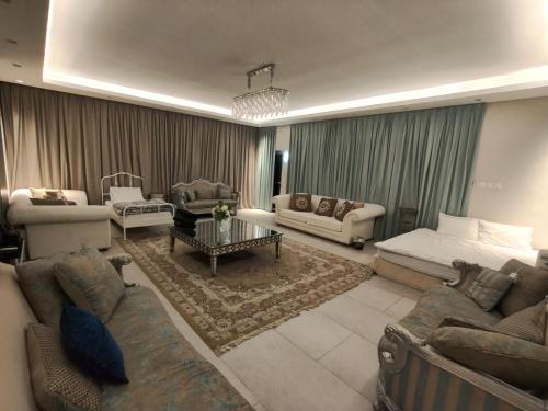 a large living room with couches and a table at Studio attached to huge villa include access to villa also in Ajman