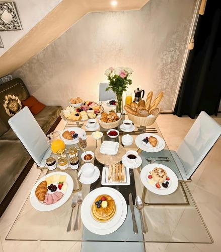 a table with plates of breakfast food on it at Studio attached to huge villa include access to villa also in Ajman