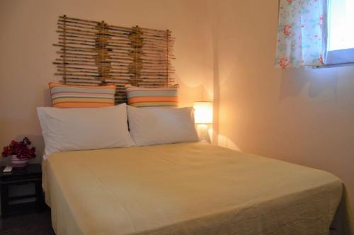 a bedroom with a bed with white sheets and pillows at Dammuso La Ginestra in Pantelleria