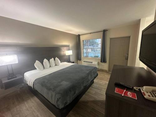 a hotel room with a bed and a flat screen tv at Econo Lodge St Petersburg Central in St. Petersburg