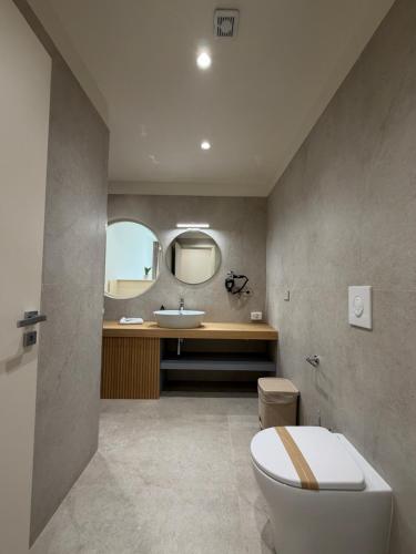 a bathroom with a white toilet and a sink at Ab aparthotel in Gizzeria