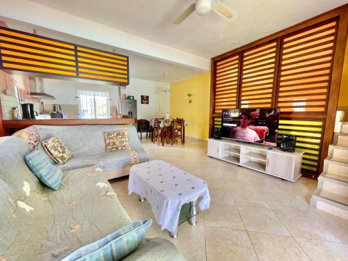 a living room with a couch and a tv at Cozy 3BR Duplex with Pool & Garden View - Grand Gaube Getaway in Grande Gaube